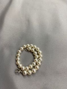 White Freshwater Pearl Bracelet. This bracelet features 28 White Freshwater Pearls AAA round to near round high luster 6.2mm with a heart clasp that is 18K white gold plate over 925 silver. The bracelet is 7 1/2 inches long measured laying flat. I hand knotted this bracelet using spectra thread. I use it instead of silk for my freshwater pearls. It does not stretch, hold oils, or break easily. It can also be gotten wet. I also like the heart clasp, they are easier to connect. We guarantee all of Elegant Pearl Bracelet With Lobster Clasp And Round Beads, Silver Single Strand Pearl Bracelet, White Single Strand Round Pearl Bracelet, Formal Pearl Bracelet With Sterling Silver Clasp, Elegant White Pearl Bracelet With Lobster Clasp, White Single Strand Pearl Bracelet, Classic Sterling Silver Bracelet With Lobster Clasp, Elegant Hypoallergenic Sterling Silver Bracelet For Formal Occasions, Classic Hypoallergenic Pearl Bracelet