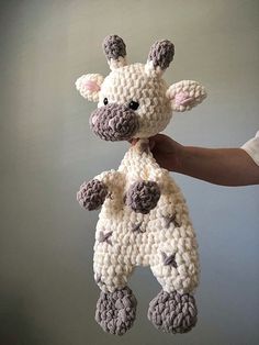 a crocheted giraffe stuffed animal being held by someone's hand