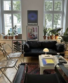 a living room filled with lots of furniture and plants on the windows sills