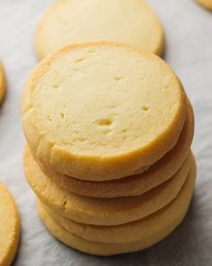 a stack of yellow cookies sitting on top of a white tablecloth covered in paper