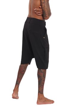 Breathable, super lightweight, water resistant active fabric meets tailored structure in these black techwear shorts. The Dublin Mens Drop Crotch Shorts have a streetwear aesthetic but function as a multi purpose garment. Comfortable enough to lounge in and suitable to swim in; the perfect shorts for travelers and spontaneous souls. FEATURES: Harem style: low dropped crotch Long length, hits just below the knee Four pockets, two with zippers, one of which is hidden Belt loops Diagonal zip fly Ma Techwear Cargo Shorts, Streetwear Techwear Shorts, Black Techwear Cargo Shorts For Outdoor, Nylon Techwear Shorts For Streetwear, Techwear Nylon Shorts With Functional Pockets, Functional Nylon Cargo Shorts For Streetwear, Black Techwear Cargo Shorts For Streetwear, Black Techwear Shorts With Side Pockets, Functional Cargo Shorts With Built-in Shorts For Streetwear