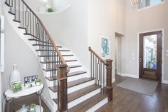 a staircase leading to the second floor in a house with hardwood floors and white walls