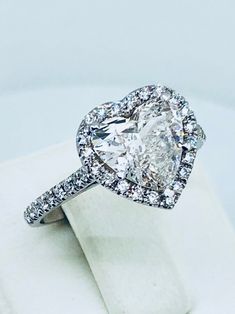 an oval shaped diamond ring on top of a white napkin