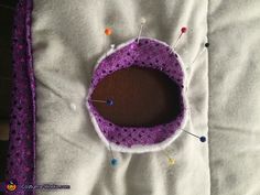 a close up of a piece of cloth with pins and needles in it on top of a pillow