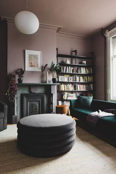 a living room filled with furniture and a fire place next to a book shelf full of books