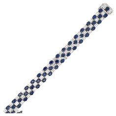 Fifty oval cut blue Sapphires weighing 24.02 Carats with alternating illusion style diamonds containing 234 round brilliants 1.49 carats and 250 baguettes weighing 6.16 carats, 18 Karat White Gold. Blue Diamond Cut Bracelet For Formal Occasions, Formal Blue Diamond-cut Bracelet, Formal Blue Diamond Cut Bracelet, Blue Oval Sapphire Diamond Bracelet, Luxury Blue Diamond Bracelet With Brilliant Cut, Blue Diamond Bracelet With Brilliant Cut Luxury Style, Luxury Blue Oval Diamond Bracelet, Blue Oval Diamond Bracelet With Jewels, Formal Blue Oval Diamond Bracelet