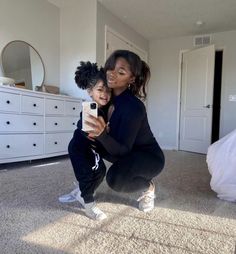 a woman taking a selfie with her daughter on the floor in front of a bed