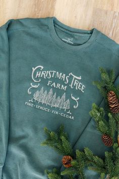 a green christmas tree farm sweatshirt with pine cones