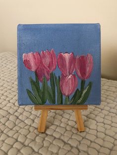 a small easel with pink flowers painted on it