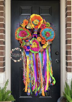 a door decorated with colorful flowers and streamers for the front entrance to a house