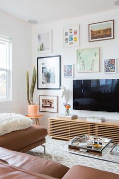 a living room filled with furniture and a large flat screen tv mounted on the wall