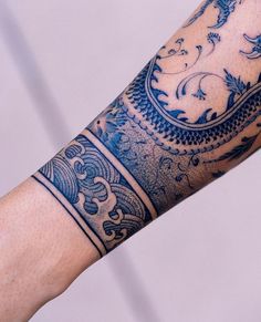 a man's arm with blue and white tattoos on it, showing the intricate design