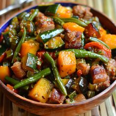 a wooden bowl filled with vegetables and meat