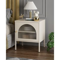 a white night stand with a lamp on top