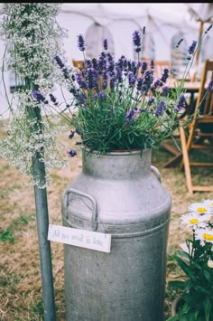 an old milk can with flowers in it and a sign that says, all you need is love