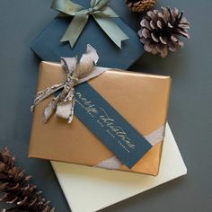 two wrapped presents with ribbons and pine cones