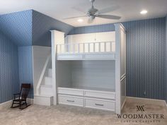 a bedroom with blue and white wallpaper and bunk bed in the corner next to stairs