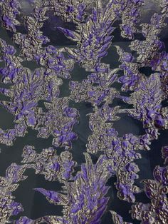 an image of purple flowers in the middle of black and silver fabric with metallic foil on it