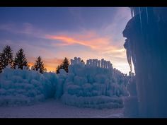 the sun is setting behind some ice formations