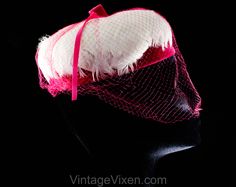 "This dome-shaped 1960s spring hat is a soft layer of thick white feathers over a base of vivid pink velvet, so charming and coy with a \"cage\" of veiling. Measurements 20 3/8 Inches Circumference at inside base of crown, approx Height 3 Inches Era 1960s Label Union label to inside back Materials White feathers, shocking pink synthetic velvet and matching diamond pattern net, matching pink stiff buckram frame Closure None needed Condition Good Condition Detail Barely worn, the netting has 6-8 s Retro Pink Brimmed Hat, Pink Fitted Cap Mini Hat, Vintage Pink Costume Hats And Headpieces For Wedding, Vintage Pink Mini Hats For Vintage Events, Pink Vintage Mini Hats For Vintage Events, Vintage Pink Wedding Costume Hat, Pink Retro Party Hats, Retro Spring Fascinator Hat, Retro Spring Fascinator