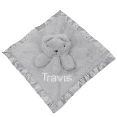 a gray teddy bear blanket with the name travis on it