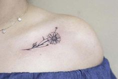 a woman with a tattoo on her chest has a dandelion flower tattooed on her shoulder