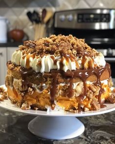 a cake sitting on top of a white plate covered in frosting and toppings