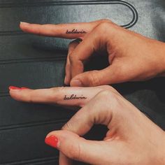 two people with matching tattoos on their fingers pointing at each other's fingernails