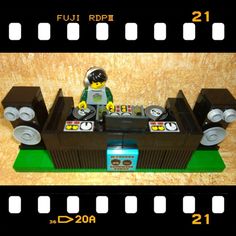 a lego man sitting on top of a table next to some speakers and tape recorders