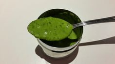 a spoon in a cup filled with green liquid