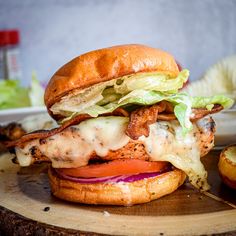 a chicken sandwich with lettuce, tomato and cheese