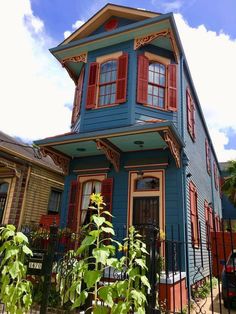 a blue house with red shutters and windows