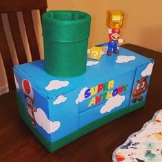 an inflatable toy box with mario on it sitting on a table next to a paper plate