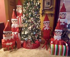 there are many elfs around the christmas tree