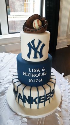 a three tiered cake with a baseball and glove on top