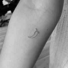 a woman's arm with a small banana tattoo on the left side of her leg