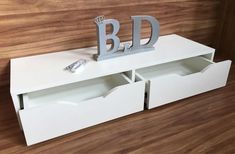 a white shelf with drawers and letters on it