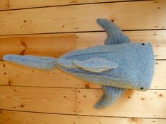 a stuffed shark is hanging on the wall next to wood planks and a wooden floor