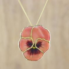 a necklace with a pink flower on it