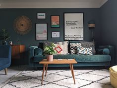 a living room with blue couches and pictures on the wall above them, along with a coffee table