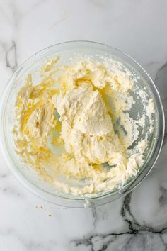 a glass bowl filled with butter on top of a marble counter