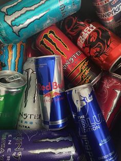 many different types of soda cans stacked on top of each other