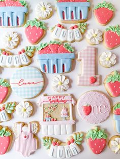 decorated cookies are arranged in the shape of strawberrys and cakes for first birthdays