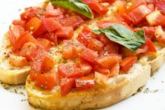 a piece of bread topped with tomatoes and basil