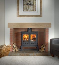 a wood burning stove with logs in front of it