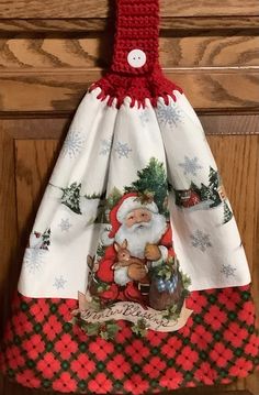 a santa clause dress hanging on a door handle with christmas decorations and snowflakes