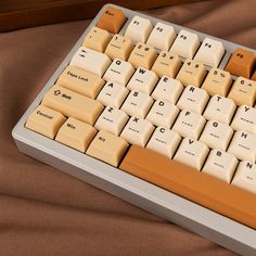 a computer keyboard sitting on top of a brown cloth covered table next to a wooden frame