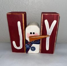 a wooden block with a snowman holding a piece of bread