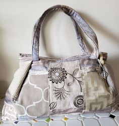 "This pretty, roomy bag will be a joy to carry.  It's made from high-quality decorator fabrics and is fully lined with two pockets inside and two pockets outside.  Seams are topstitched for strength and beauty, and I use durable handbag zippers.   Note the pretty zipper pull.  The bag measures 15\" w at the top, 18\"w at the bottom, 11\"h and 4\"d.  The handles are 22\" long.   Hand wash and line dry.  Cotton, linen, and synthetic. The profits from my sales are donated to many organizations, including the United Nations Children's Emergency Fund, United Nations High Command for Refugees, The  Redford Theater, Dabls African Bead Museum, Community Sharing, the Village Fine Arts Association,  Mittens for Detroit, and Doctors Without Borders." Fabric Shoulder Bag With Pockets For Daily Use, Canvas Bag With Pockets For Everyday Use, Everyday Fabric Shoulder Bag With Pockets, Everyday Canvas Bag With Pockets, Fabric Shoulder Bag With Pockets For Travel, Fabric Shoulder Bag With Zipper Pocket For Daily Use, Daily Use Fabric Shoulder Bag With Zipper Pocket, Beige Tote Satchel With Cell Phone Pocket, Fabric Shoulder Bag With Zipper Pocket For Travel