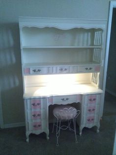 a white desk with pink drawers and chairs